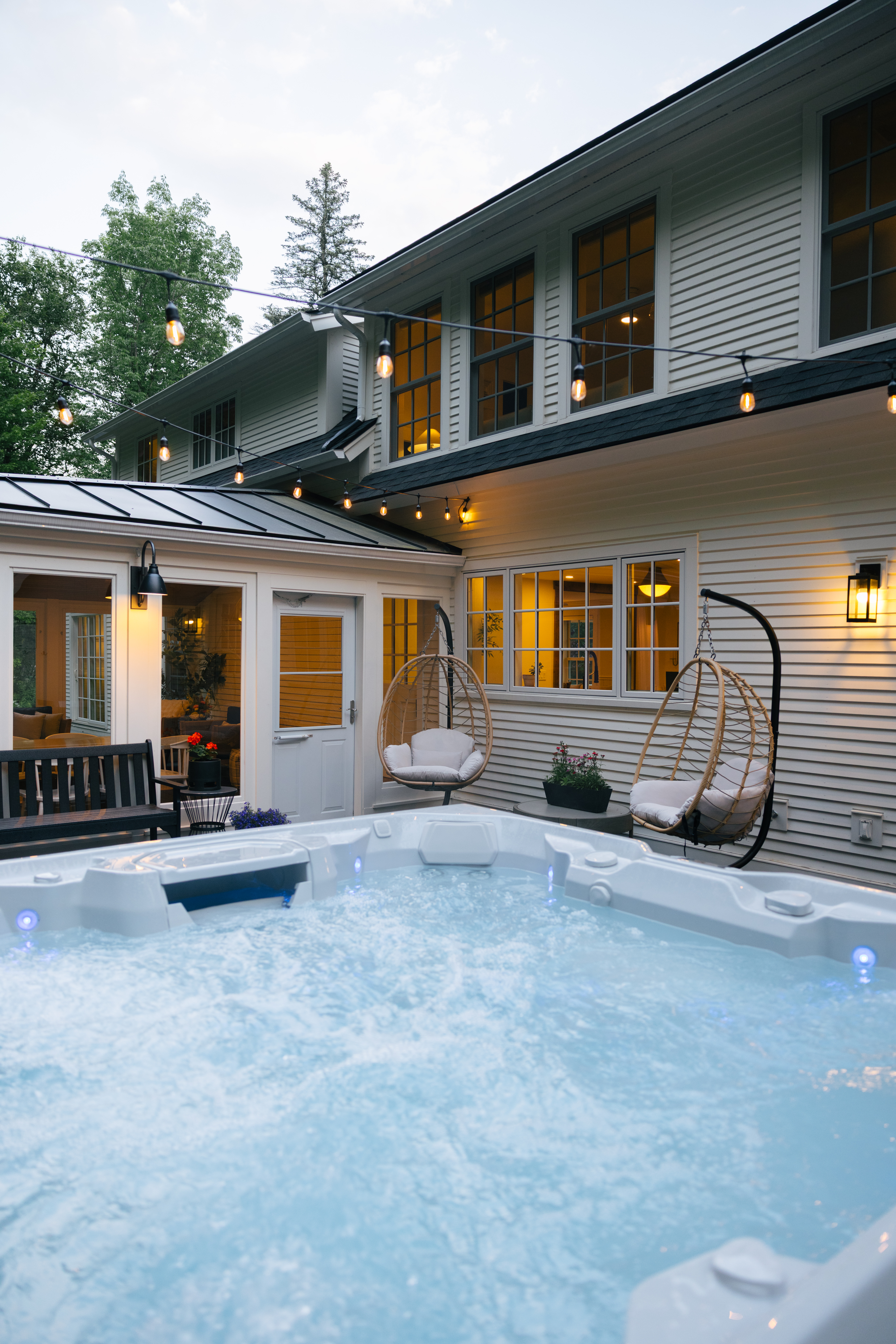 Outdoor hot tub nestled among trees, on the back patio of Mile Away